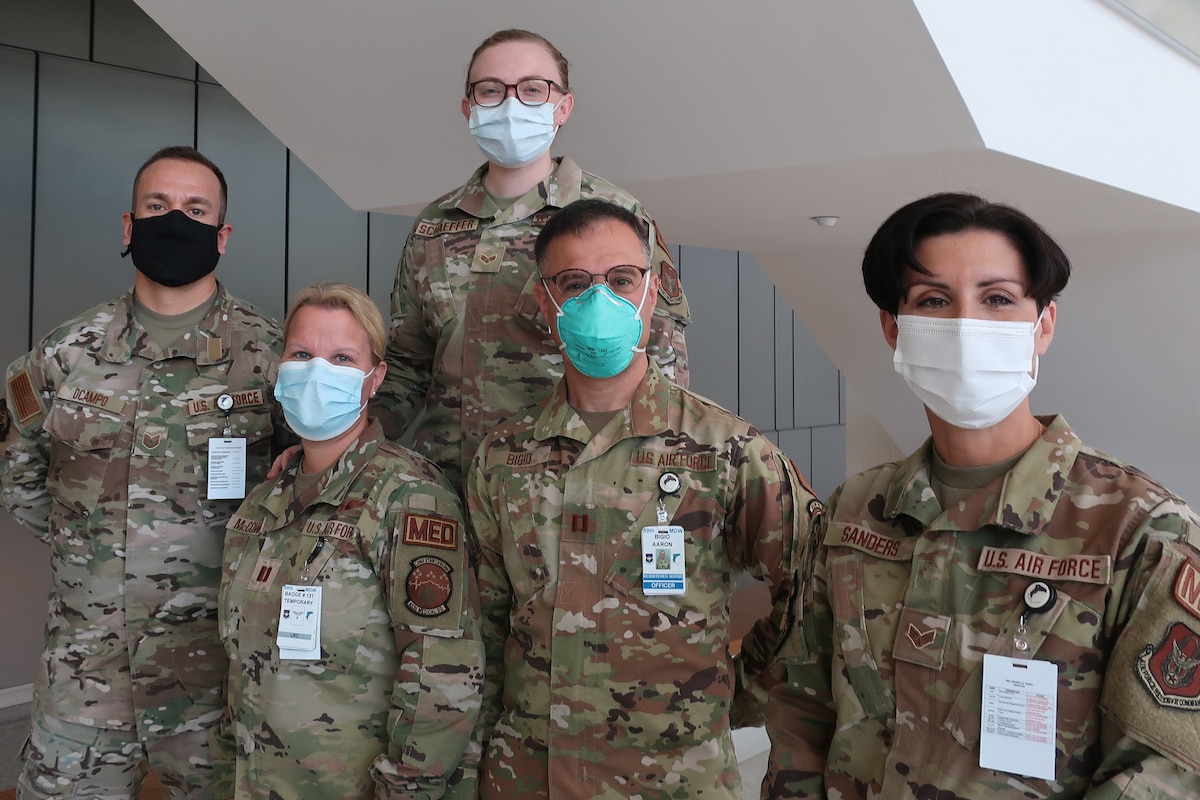 Airmen wearing masks pose for a photo