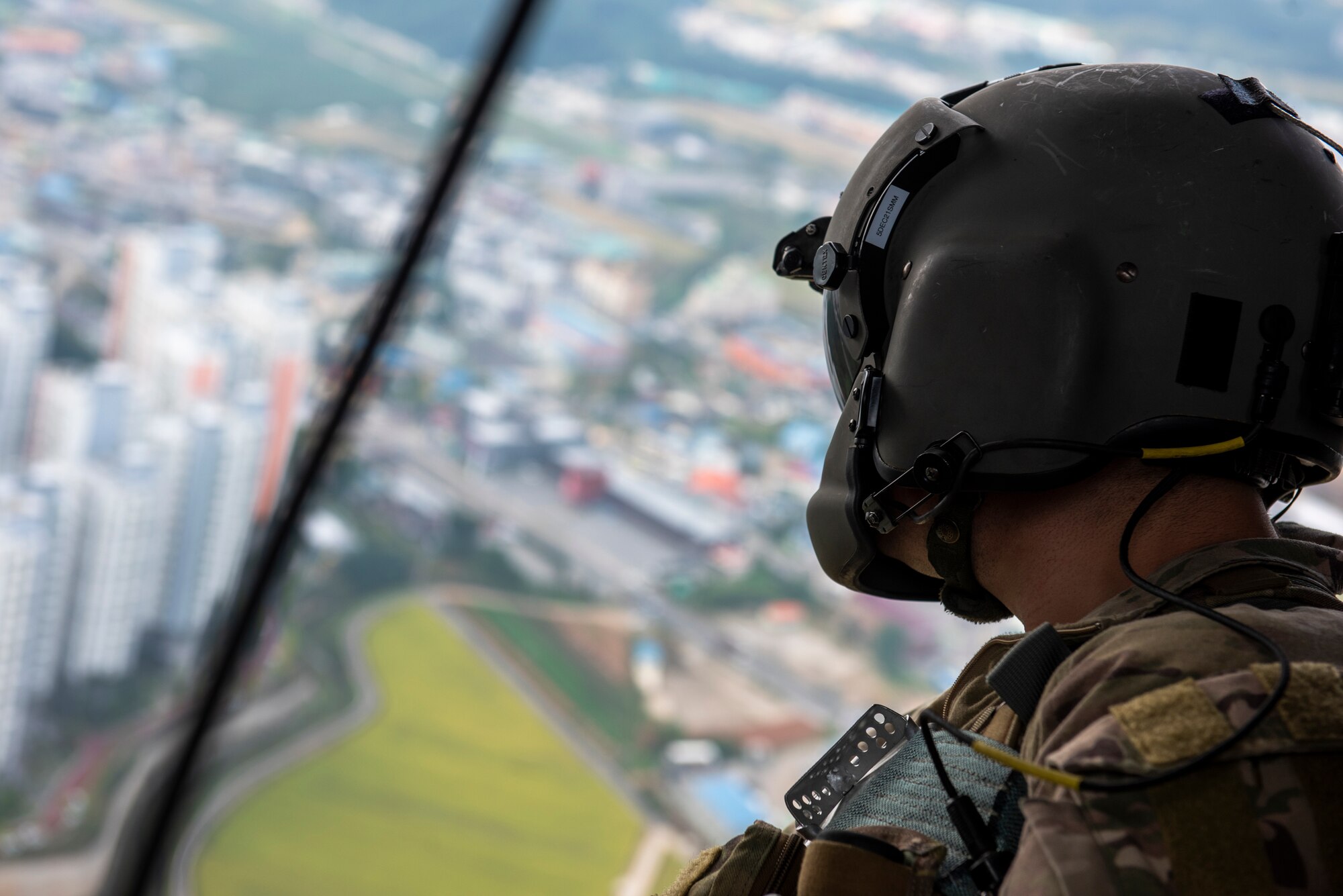Senior Airman Eaven Allison, 33rd Rescue Squadron special missions aviator, looks out over the landscape from inside of an HH-60G Pave Hawk helicopter during a combat search and rescue training event