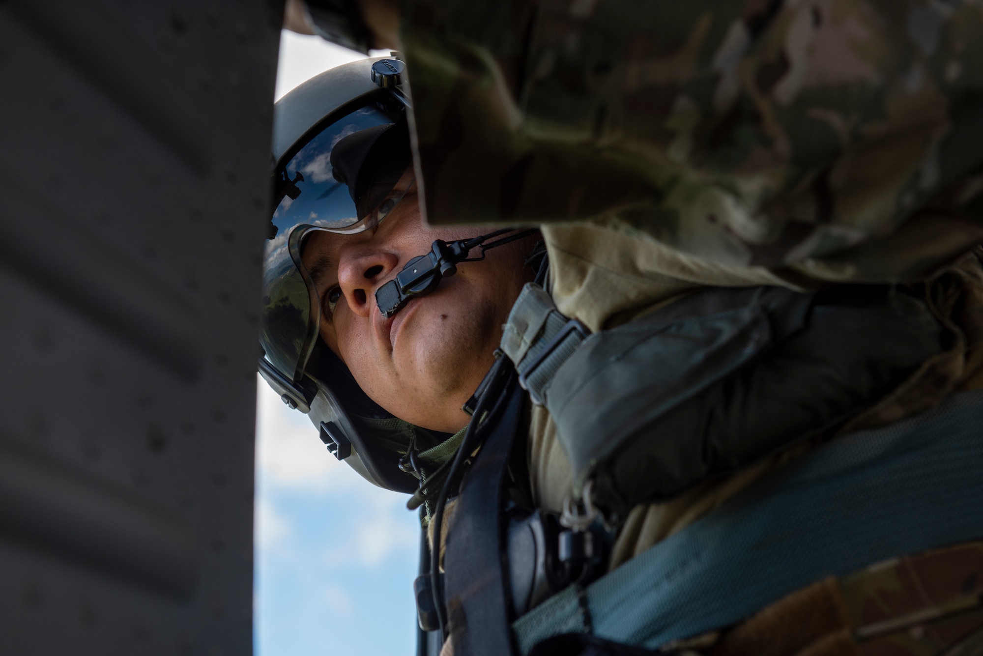 Staff Sgt. Alejandro Menchaca, 33rd Rescue Squadron special missions aviator, looks for flanking HH-60G Pave Hawk helicopters during a combat search and rescue training event
