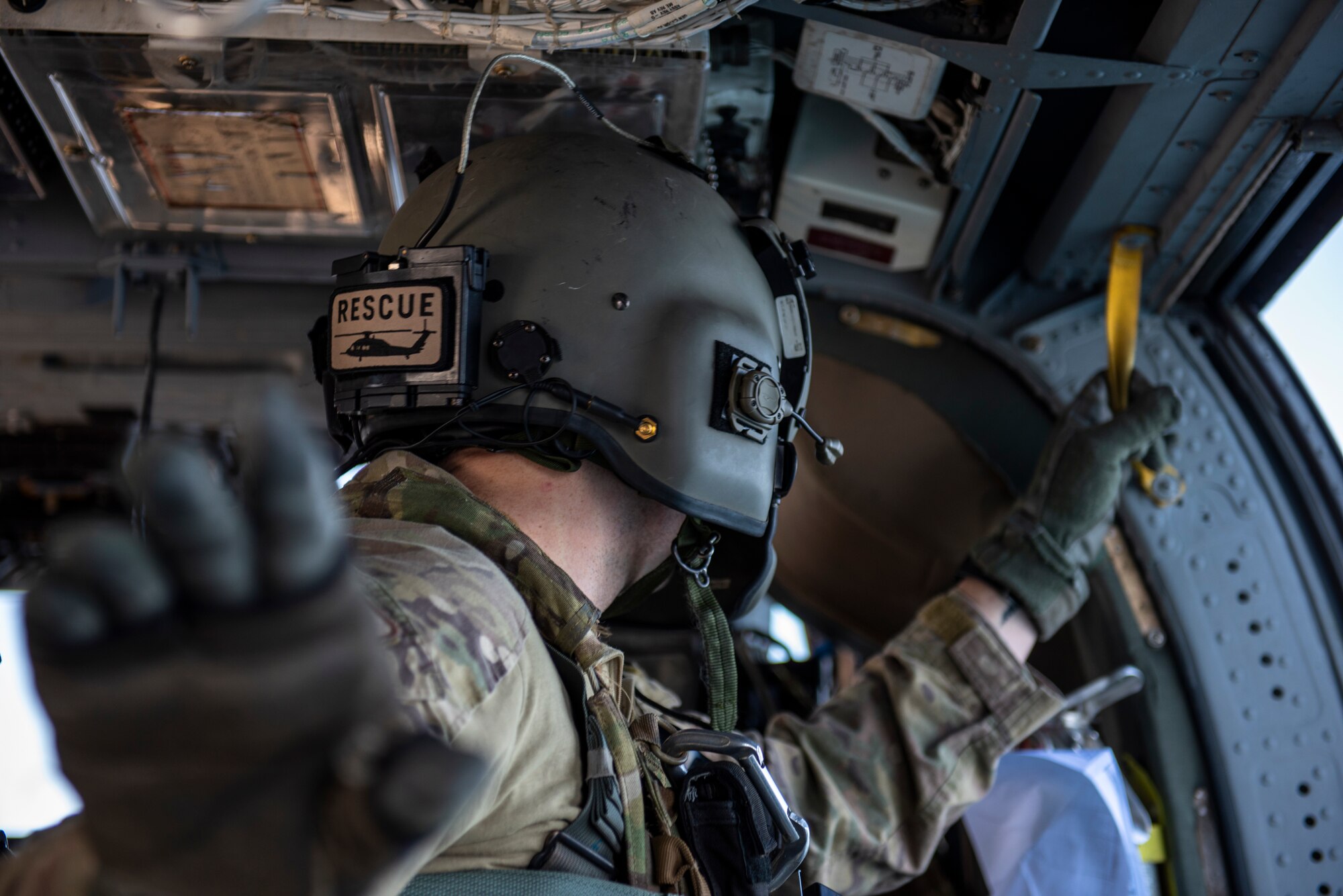 Senior Airman Gaige Clidinst, 33rd Rescue Squadron special missions aviator, searches for the rescue subject during a combat search and rescue training event