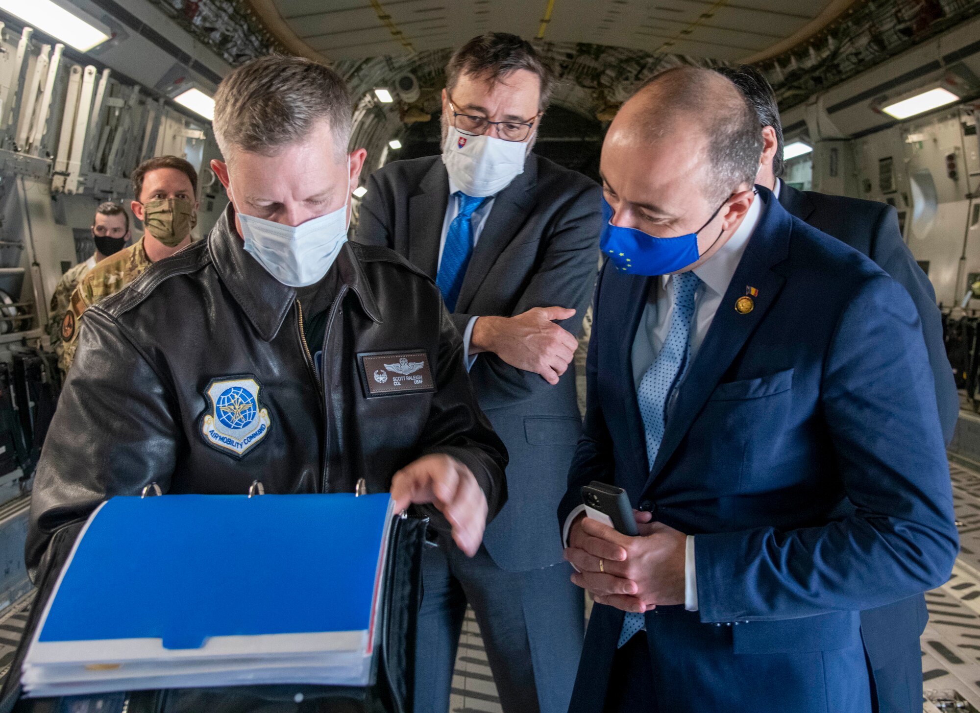 Col. Scott Raleigh, left, 436th Operations Group commander, discusses maintenance forms for a C-17 Globemaster III with Slovakian Ambassador to the United States, Radovan Javorčík, middle, and Romanian Ambassador to the U.S., Andrei Muraru, on Dover Air Force Base, Delaware, Oct. 18, 2021. The forms document any maintenance performed on the aircraft, as well as verify the aircraft is ready to fly. (U.S. Air Force photo by Tech. Sgt. Nicole Leidholm)