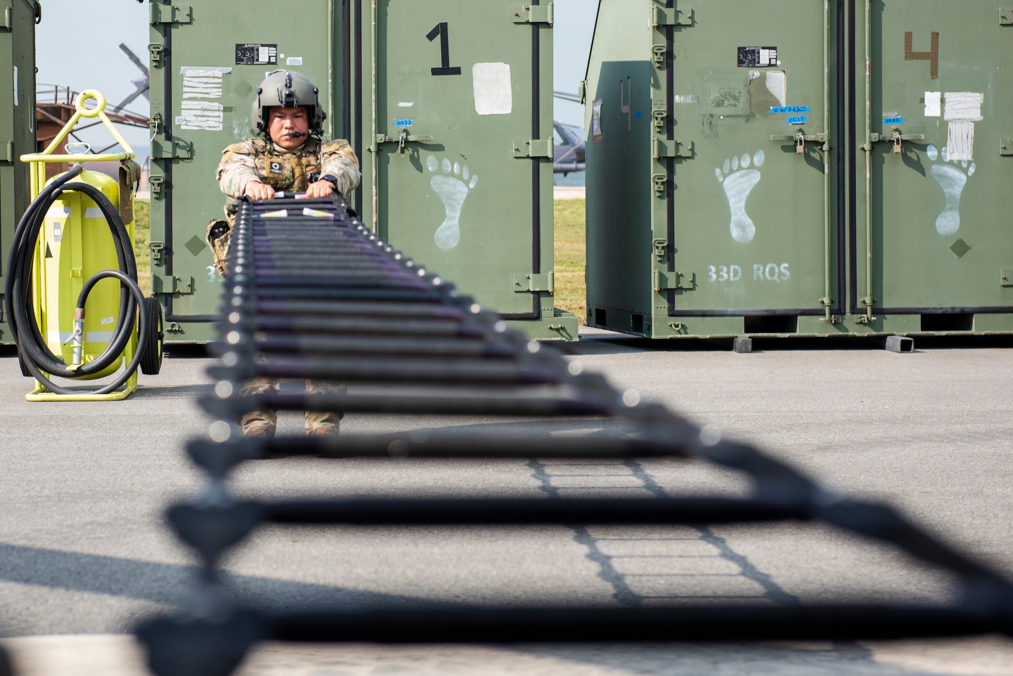 Staff Sgt. Alejandro Menchaca, 33rd Rescue Squadron special missions aviator, rolls up a rescue ladder into an HH-60G Pave Hawk helicopter during a combat search and rescue training event