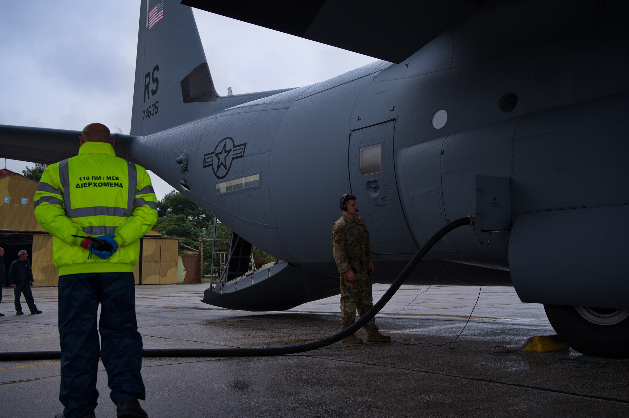 U.S. Air Force Staff Sgt. Kyle Hodge, right, 86th Aircraft Maintenance Squadron flying crew chief, monitors a C-130J Super Hercules aircraft  being refueled during Operation Castle Forge at Larissa Air Base, Greece, Oct. 15, 2021. Castle Forge is a U.S. Air Forces Europe-Air Forces Africa-led joint, multinational training event. It provides a dynamic, partnership-focused training environment, raising the U.S. commitment to collective defense in the Black Sea region while enhancing interoperability alongside NATO allies. (U.S. Air Force photo by Senior Airman Branden Rae)