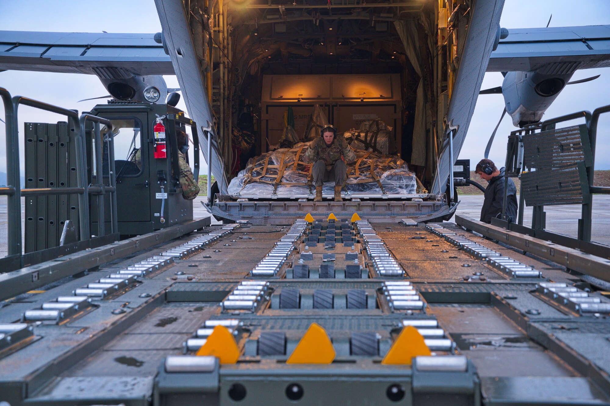 U.S. Air Force Tech. Sgt. Alex White, 37th Airlift Squadron instructor loadmaster, directs the placement of a material handling equipment loader during Operation Castle Forge at Larissa Air Base, Greece, Oct. 15, 2021. Castle Forge is a U.S. Air Forces Europe-Air Forces Africa-led joint, multinational training event designed to raise and strengthen the U.S.' commitment to the Black Sea allies and partnerships while also demonstrating rapid, forward deployed support to the U.S European Command area of responsibility. (U.S. Air Force photo by Senior Airman Branden Rae)
