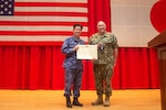 YOKOSUKA, Japan (Oct. 21, 2021) - Rear Adm. Will Pennington receives an award from Vice Adm. SAITO Akira, commander of Japan Maritime Self-Defense Force (JMSDF) Fleet Escort Force during the change of command ceremony for Commander, Task Force (CTF) 70 in the Benny Decker Theater on Yokosuka Naval Base, Oct. 21. (U.S. Navy photo by Mass Communication Specialist 3rd Class Askia Collins)