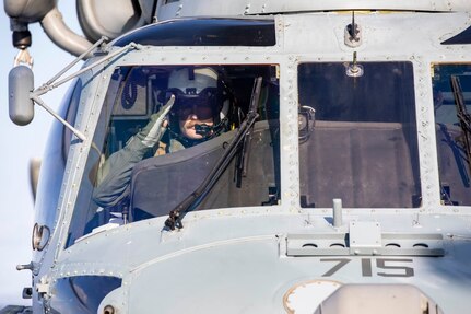 Pilot in helicopter saluting.