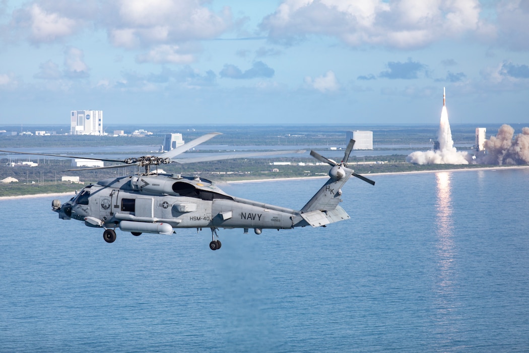 Helicopter flying over water.