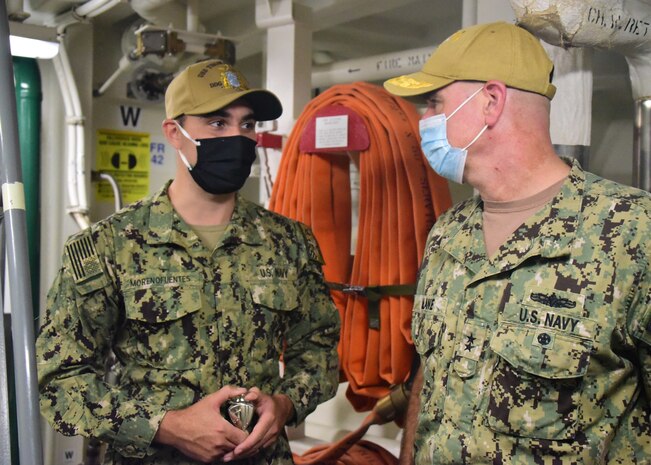 Seaman Moreno Fuentes, assigned to the guided-missile destroyer USS Thomas Hudner (DDG 116), is presented a challenge coin by Rear Adm. Brendan McLane, commander, Naval Surface Force Atlantic. (U.S. Navy photo by IT2 Cachola)