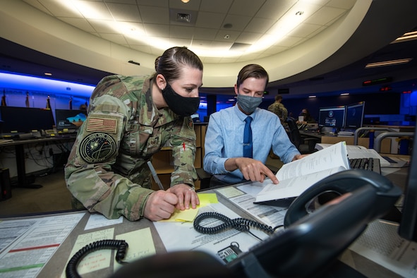 Two intelligence professionals work together in the Joint Task Force-Space Defense.