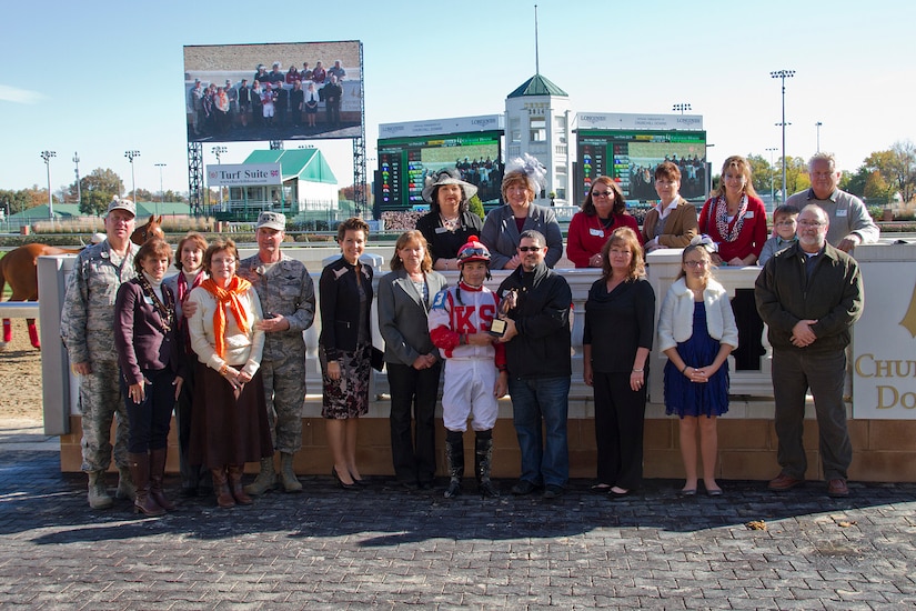 Surviving family members of fallen U.S. service members are joined by Heather French Henry, commissioner of Kentucky’s Department of Veterans Affairs, the vice chief of the National Guard, Lt. Gen. Joseph L. Lengyel, Adjutant General Maj. Gen. Edward W. Tonini in the winners’ circle at Churchill Downs in Louisville, Ky., Nov. 4, 2014, to present a trophy to the winning jockey of a race race named in honor of the fallen. The families gathered at the track for the fifth annual Survivors Day at the Races organized by Survivors Outreach Services.