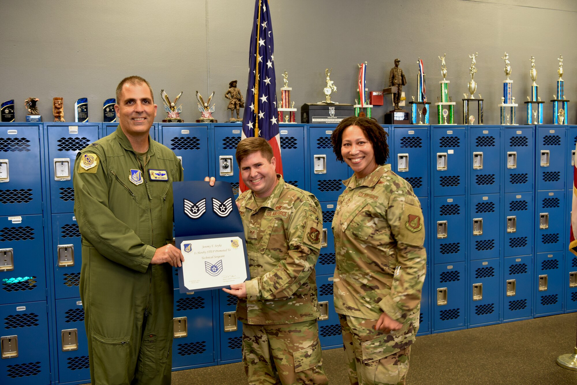 Col. Daniel Dobbels (left), 15th Wing commander, and Chief Master Sgt. Sheronne King (right), 15th WG command chief, award Tech. Sgt. Jeremy Soyke (center), 15th Aircraft Maintenance Squadron crew chief, his Stripes for Exceptional Performers promotion at Joint Base Pearl Harbor-Hickam, Hawaii, 15 Oct., 2021. STEP promotions are awarded to enlisted Airmen who demonstrate exceptional potential to the grades of Staff Sgt. or Tech. Sgt. (U.S. Air Force photo by 1st Lt. Benjamin Aronson)