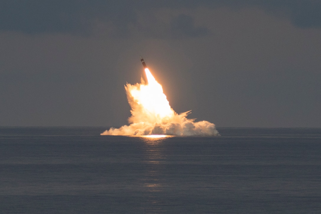 A missile launches from a ship at sea.