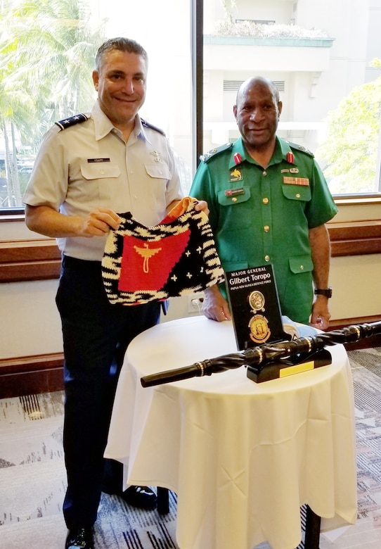 Maj. Gen Gilbert Toropo, the Papua New Guinea chief of defense, presents Maj. Gen. Paul Knapp, Wisconsin’s adjutant general, with a gift in September 2021 in Hawaii. Knapp visited Hawaii to meet with Toropo and attend a series of conferences in conjunction with the Wisconsin National Guard’s partnership with Papua New Guinea through the State Partnership Program.