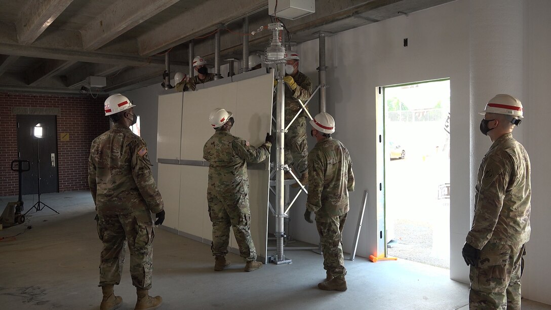 Members of the 412th Theater Engineer Command work to assemble the Expedient Retrofit for Existing Buildings system. (U.S. Army Corps of Engineers photo)