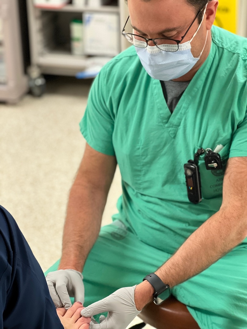 Dr. John Destefano, podiatrist, examines the toes and foot of a patient at Bayne-Jones Army Community Hospital.