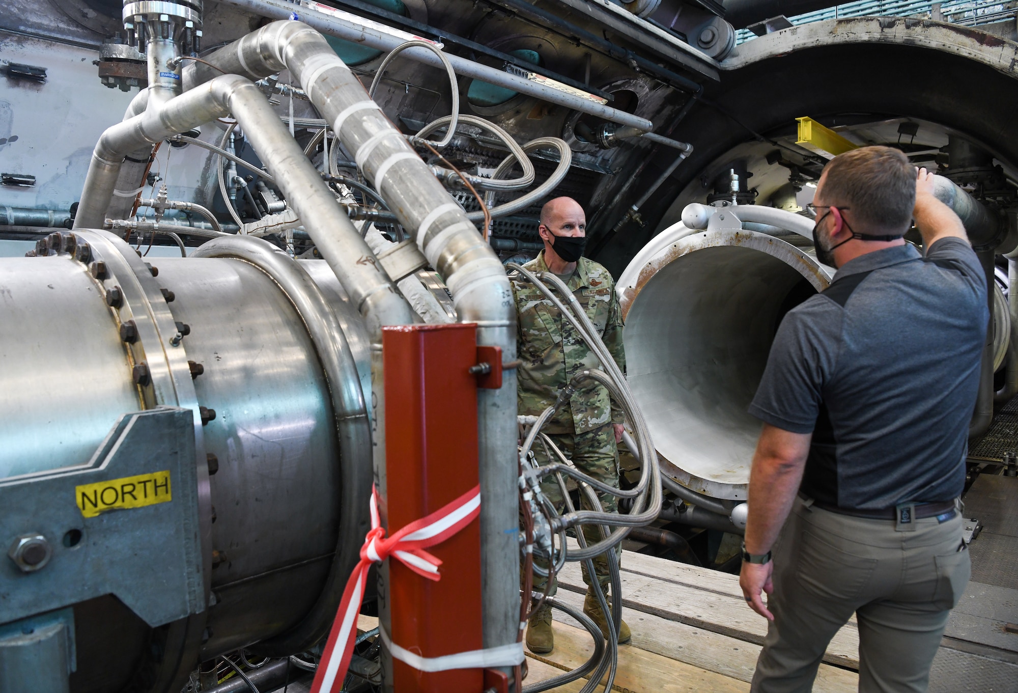 Kirk Butler, right, director of operations for the Hypersonic Systems Test Branch of Arnold Engineering Development Complex, explains how the Aerodynamic and Propulsion Test Unit operates to Maj. Gen. Evan Dertien, commander, Air Force Test Center, during Dertien's visit to Arnold Air Force Base, headquarters of AEDC, Oct. 13, 2021. The Hypersonic Systems Test Branch of AEDC provides a unique, vertically-integrated capabilities set to support the hypersonic testing needs of the Department of Defense. The Branch is involved in every step of the developmental process for test and evaluation of hypersonic systems. (U.S. Air Force photo by Jill Pickett)