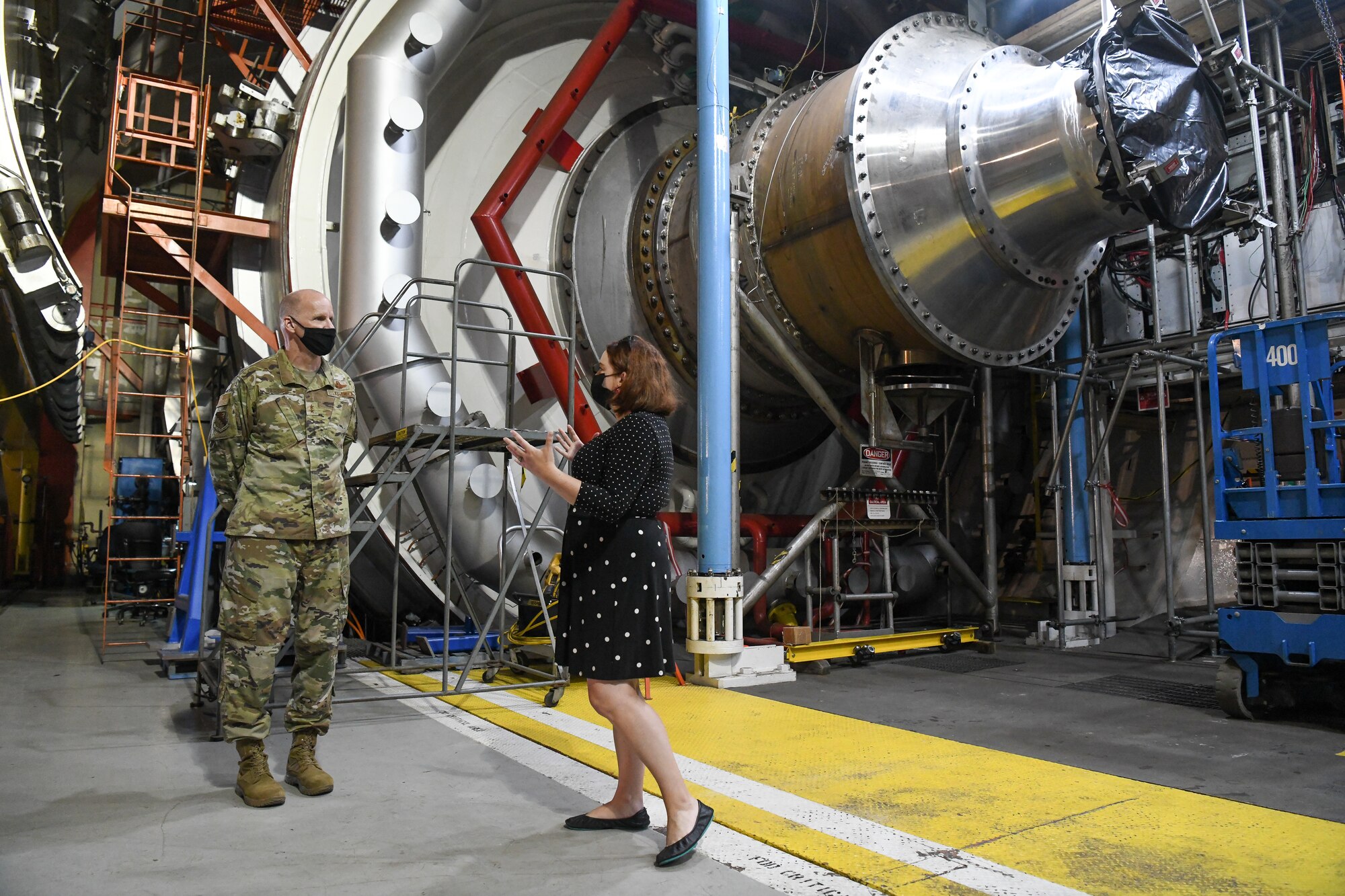 Rachel Garrard, a test manager with the Propulsion Test Branch of Arnold Engineering Development Complex (AEDC), explains how the C-1 altitude engine test cell works to Maj. Gen. Evan Dertien, commander, Air Force Test Center, during Dertien's visit to Arnold Air Force Base, headquarters of AEDC, Oct. 13, 2021. In C-1, large military and commercial engines are tested at simulated altitude conditions. In recent years, C-1 has primarily been used to test F119 engines for the F-22 Raptor and the F135 engines for the F-35 Lightning II. (U.S. Air Force photo by Jill Pickett)