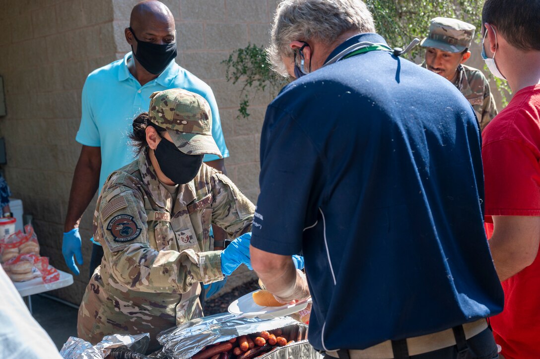 A photo of Staff Sgt. Brittany Coker passing out food at AbilityOne picnic.