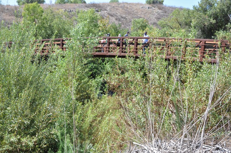 The team from U.S. Army Corps of Engineers Los Angeles District pause on a abridge, Sept .16, spanning Aliso Creek near Laguna Beach, California. The tour of restored natural habitats was led by OCTA's environmental project manager, Leslie Hill, Restoring the riparian zone brought back numerous species of native birds the most diverse bird habitat in Orange County.