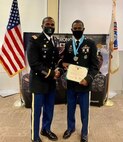 Two men standing in Army Service Uniform, receiving an award.