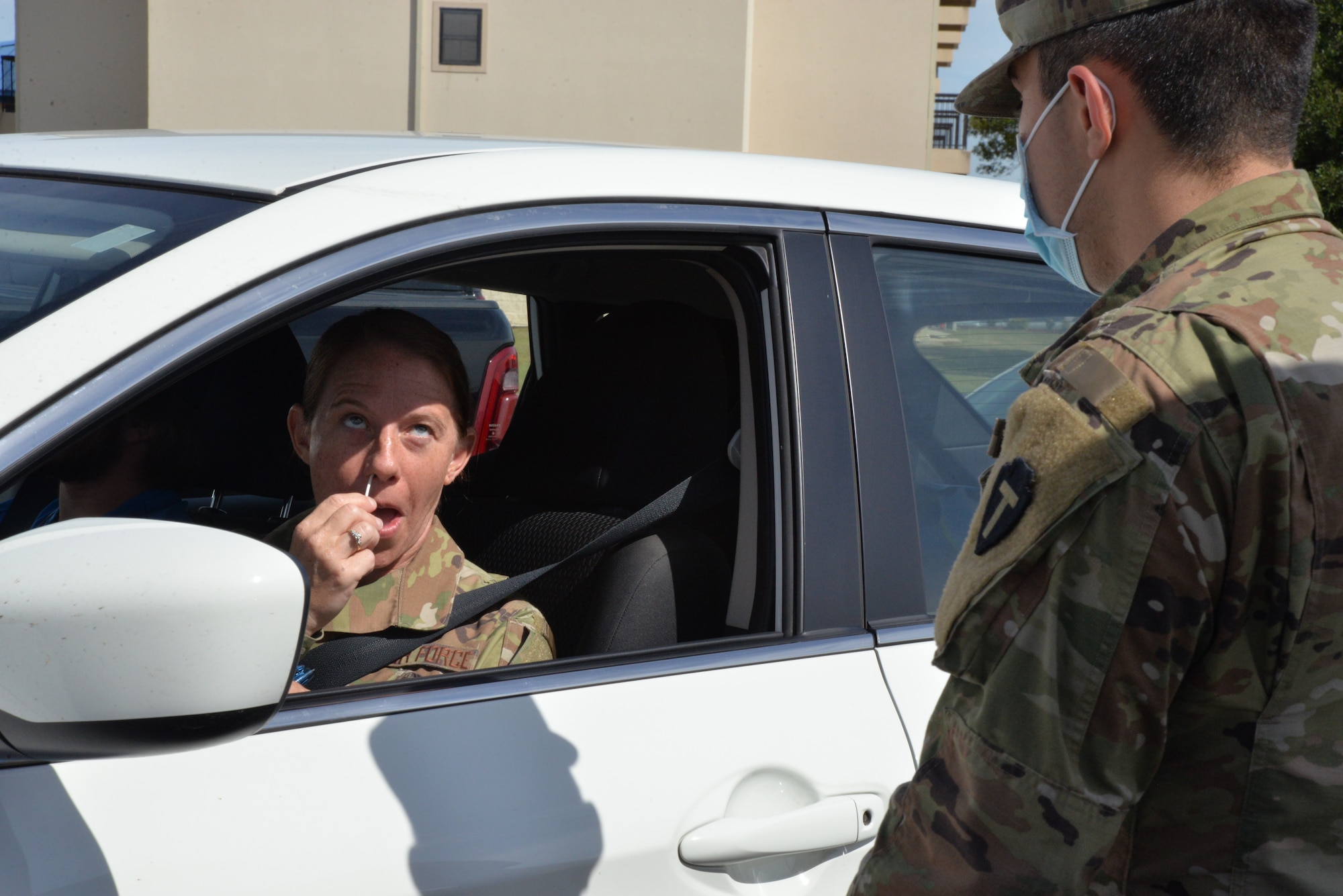 Airman swabs nose with COVID test swab.