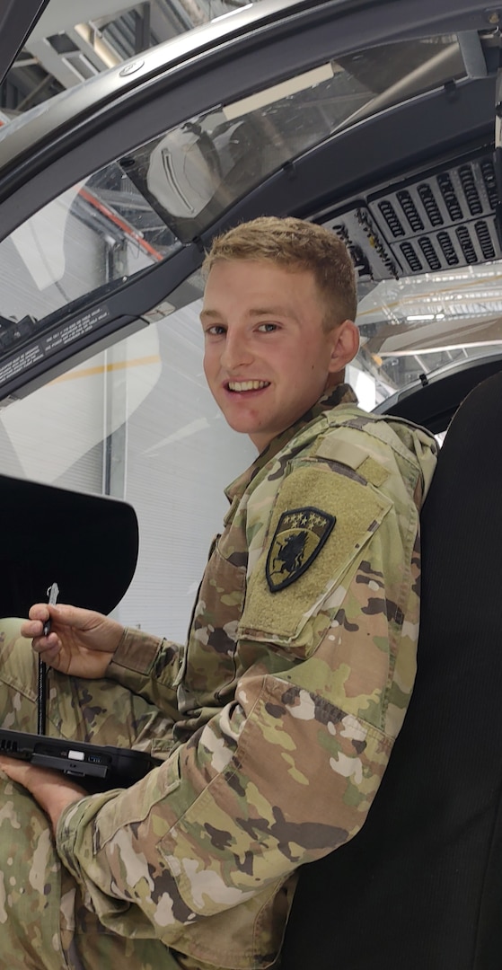 Pfc. Eli Nielsen, a Black Hawk helicopter mechanic assigned to Detachment 2, Charlie Company, 1st Battalion, 224th Aviation Regiment, Vermont National Guard, inspects an aircraft interior at the Army Aviation Support Facility, South Burlington, Vermont, on Oct. 12, 2021.  Nielsen is also a member of the Vermont National Guard Biathlon Team. (U.S. Army National Guard photo by Joshua T. Cohen)