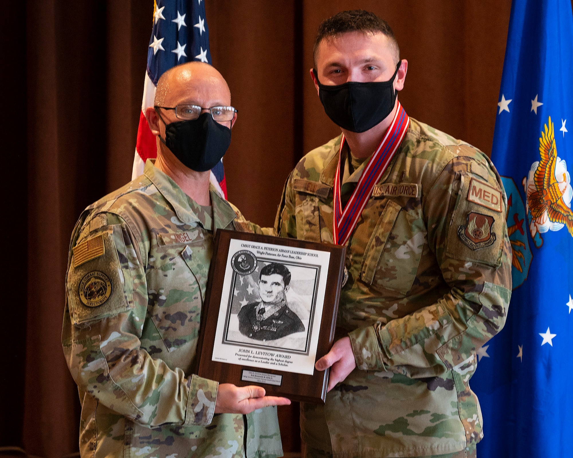 Chief Master Sgt. Theodore Angel (left), of the Air Force Life Cycle Management Center’s Aircrew Performance Branch, presents Senior Airman Kenneth Ellis, 88th Medical Group, with the John L. Levitow Award during the Airman Leadership School graduation Oct. 14, 2021 in the Wright-Patterson Club. The Levitow Award, which goes to the top graduate, is the Air Force’s highest honor for enlisted professional military education and presented to the student who demonstrates the most outstanding leadership and scholastic achievement. (U.S. Air Force photo by R.J. Oriez)