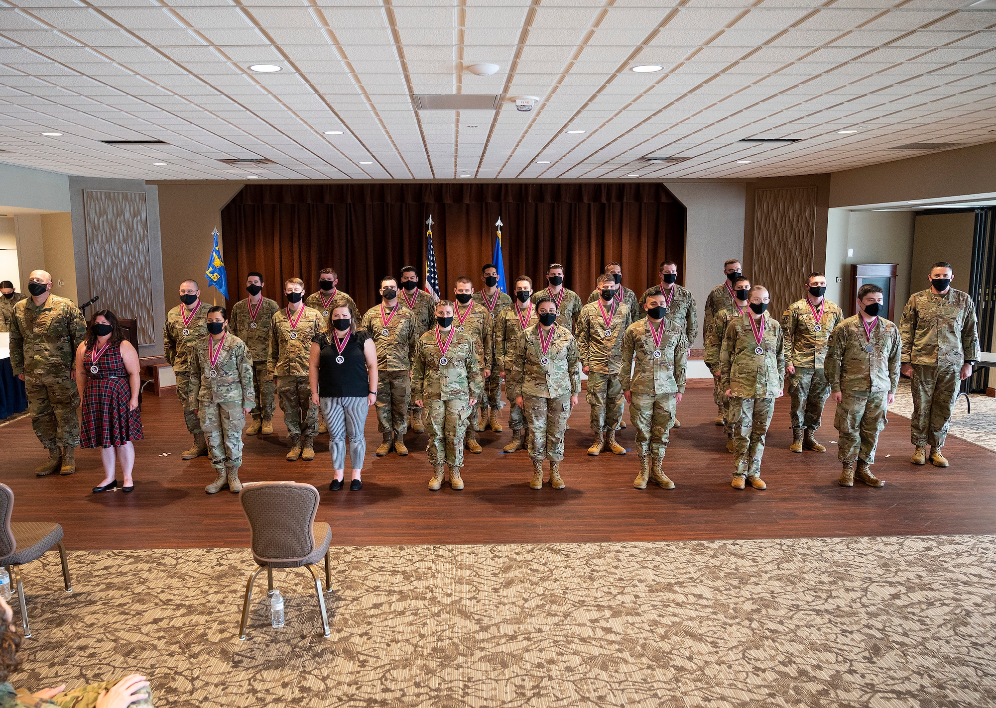 Airman Leadership School Class 21-G poses for a class photo with Col. Patrick Miller (far left), 88th Air Base Wing and installation commander, and Chief Master Sgt. Jason Shaffer (far right), 88 ABW command chief, at the end of its graduation ceremony Oct. 14, 2021, in the Wright-Patterson Club. ALS is required for staff sergeant selects and open to eligible civilians as Airmen learn more about leadership and Air Force culture. (U.S. Air Force photo by R.J. Oriez)