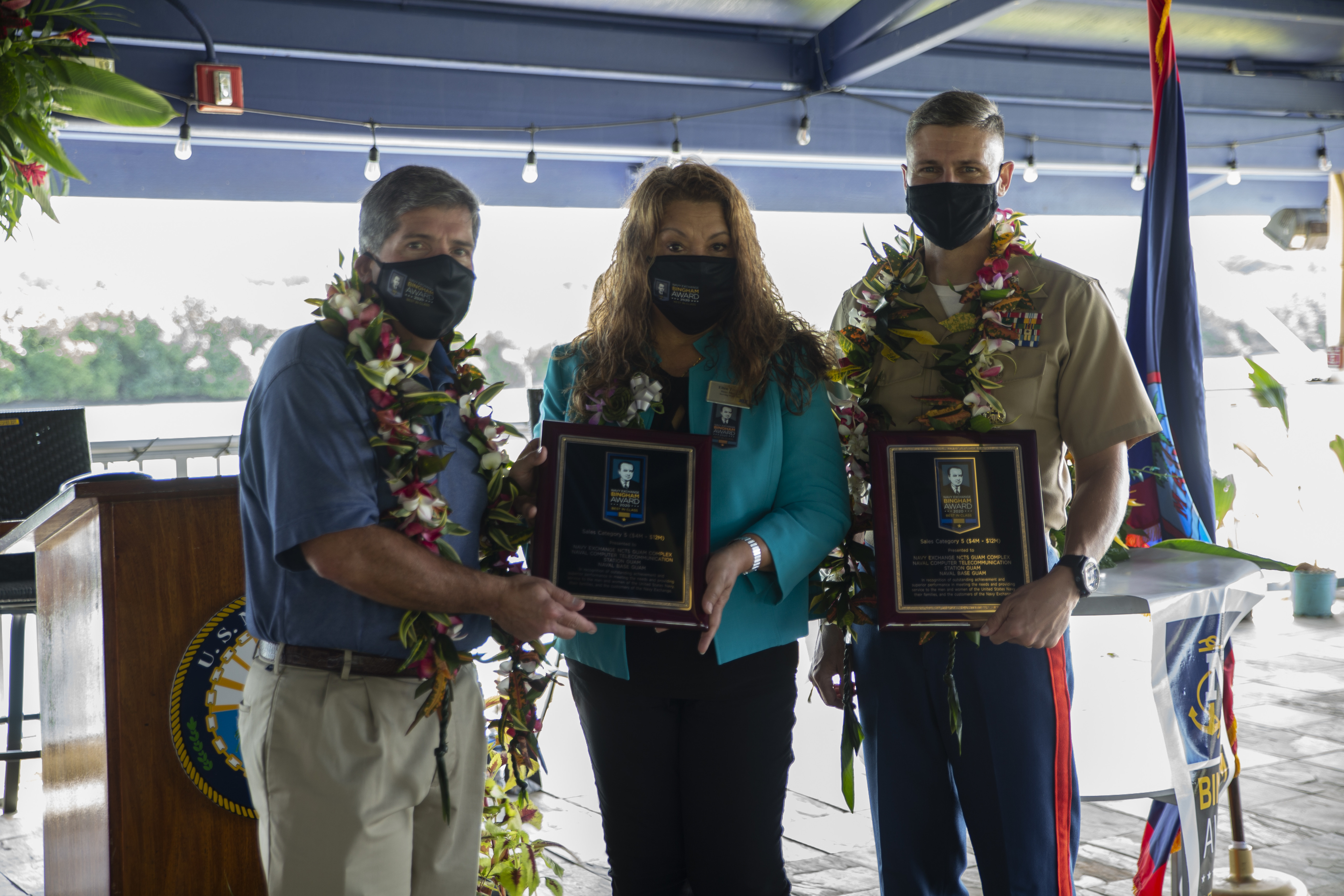 Robert Bianchi, the chief executive officer of Navy Exchange Service Command (NEXCOM), left, Ellen Tenorio, the store manager of the Naval Computer and Telecommunications Station Guam (NCTS) Naval Exchange (NEX), center, and U.S. Marine Corps Col. Christopher Bopp, the Marine Corps Base Camp Blaz commanding officer, pose for a group photo during an award ceremony held on U.S. Naval Base Guam, Oct. 14, 2021.
