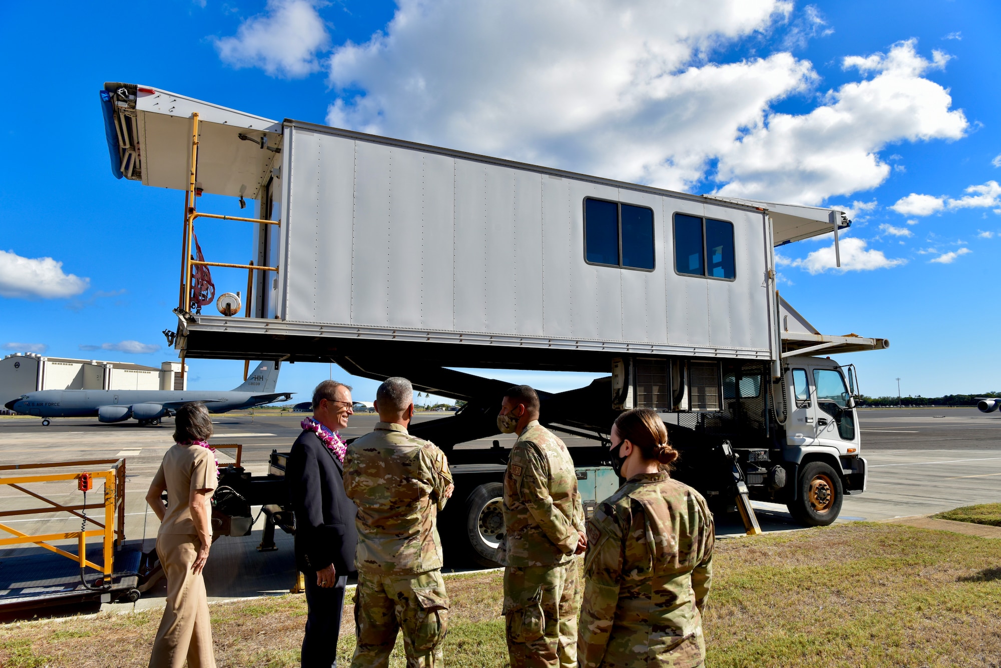 Dr. Brian Lein, Defense Health Agency assistant director, is shown a High Deck Loading Platform vehicle on the flight line at Joint Base Pearl Harbor-Hickam, Hawaii, Oct. 19, 2021. The HDLP vehicle assists with transitioning patients and medical equipment on and off of aircraft for medical airlift missions. (U.S. Air Force photo by 1st Lt. Benjamin Aronson)