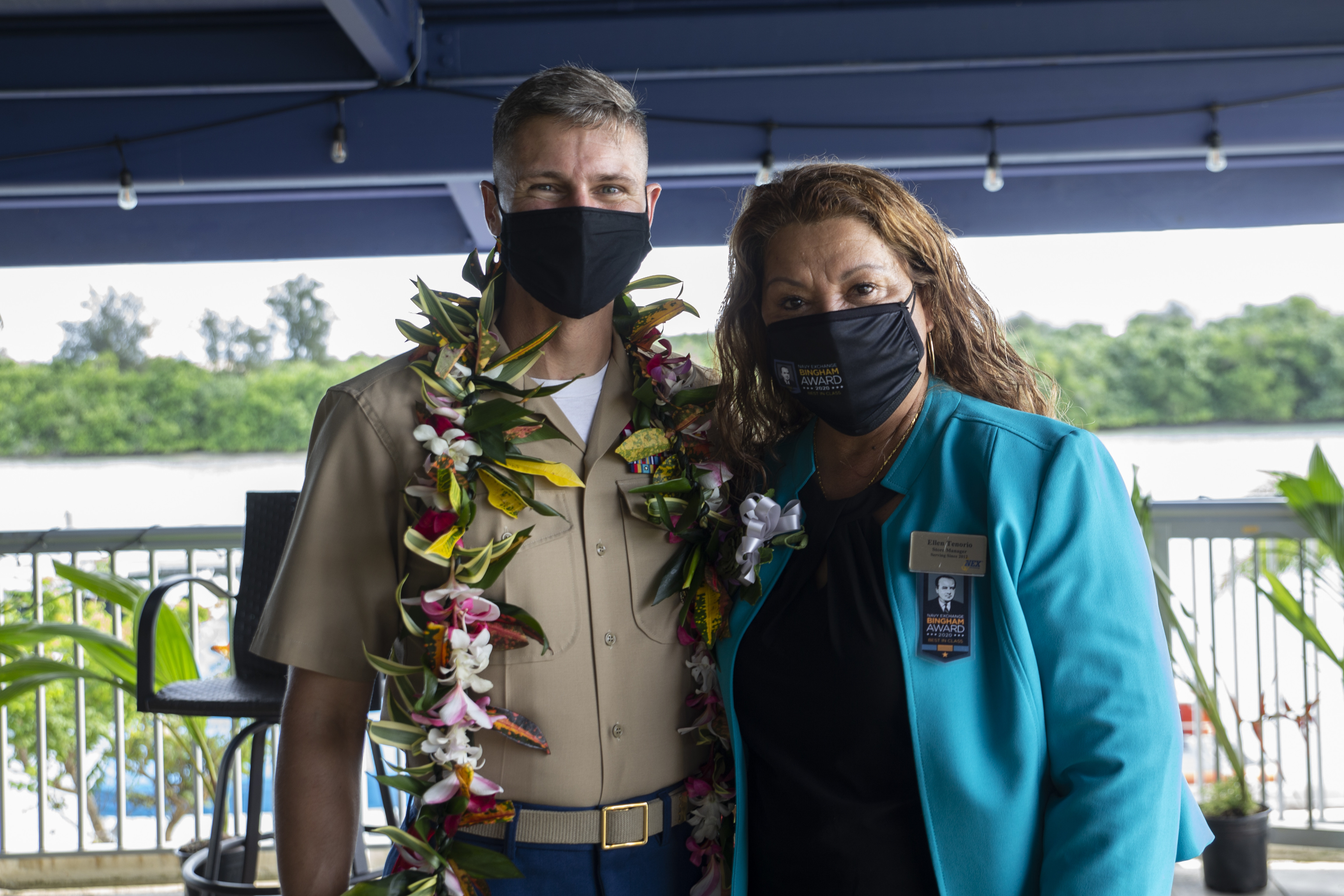 U.S. Marine Corps Col. Christopher Bopp, the Marine Corps Base Camp Blaz commanding officer, left, and Ellen Tenorio, the store manager of the Naval Computer and Telecommunications Station Guam (NCTS) Naval Exchange (NEX), pose for a photo during an award ceremony held on U.S. Naval Base Guam, Oct. 14, 2021.
