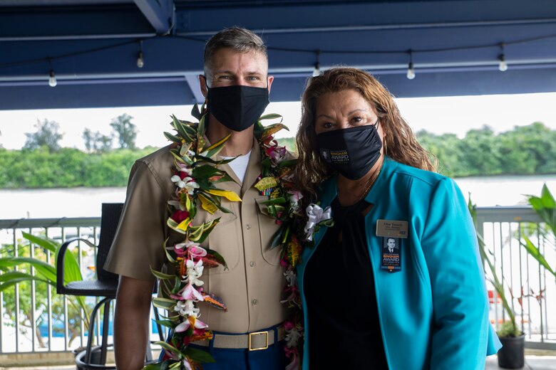 U.S. Marine Corps Col. Christopher Bopp, the Marine Corps Base Camp Blaz commanding officer, left, and Ellen Tenorio, the store manager of the Naval Computer and Telecommunications Station Guam (NCTS) Naval Exchange (NEX), pose for a photo during an award ceremony held on U.S. Naval Base Guam, Oct. 14, 2021.
