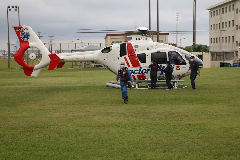 沖縄県のドクターヘリがキャンプ・シュワブのヘリ着陸帯へ到着し、機内から飛び出してきたフライトドクターと救急隊、２０２１年１０月２１日、米海兵隊基地キャンプ・シュワブ
