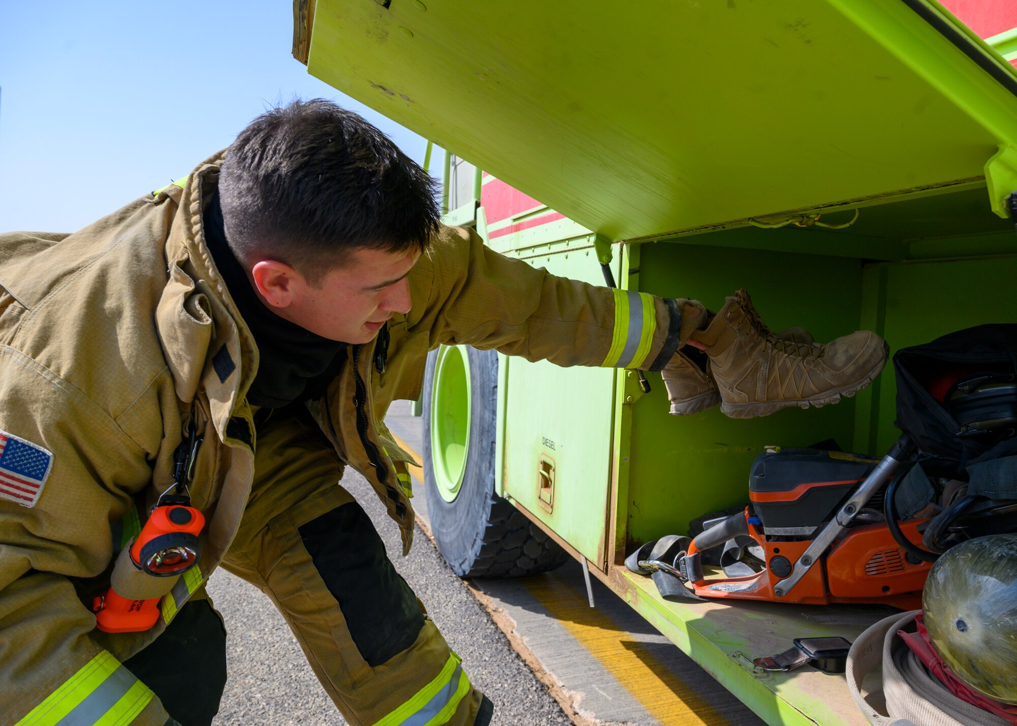 U.S. Air Force Senior Airman Trey Moore, 378th Expeditionary Civil Engineer Squadron lead rescueman, dawns his gear during an emergency response bilateral exercise with the Royal Saudi Air Force, Prince Sultan Air Base, Kingdom of Saudi Arabia, Sept. 6, 2021. The exercise was integral to maintaining a working relationship between RSAF and USAF first responders and ensuring seamless integration in case of future emergencies at PSAB. (U.S Air Force photo by Senior Airman Samuel Earick)