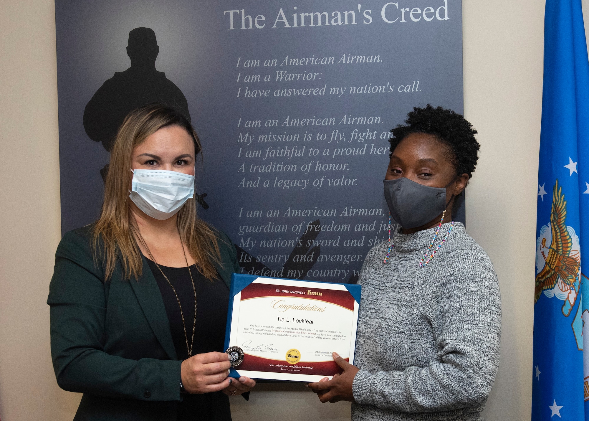 Mary Moore (left), Air Force Materiel Command alternate master process officer, presents Tia Locklear, 88th Force Support Squadron process manager, with a certificate and coin, Oct. 14, 2021 for her completion of the Masterminds course based on John C. Maxwell’s book “Everyone Communicates, Few Connect” at Wright-Patterson Air Force Base, Ohio. The course teaches strategies to ensure communication is effective. (U.S. Air Force photo by Jaima Fogg)