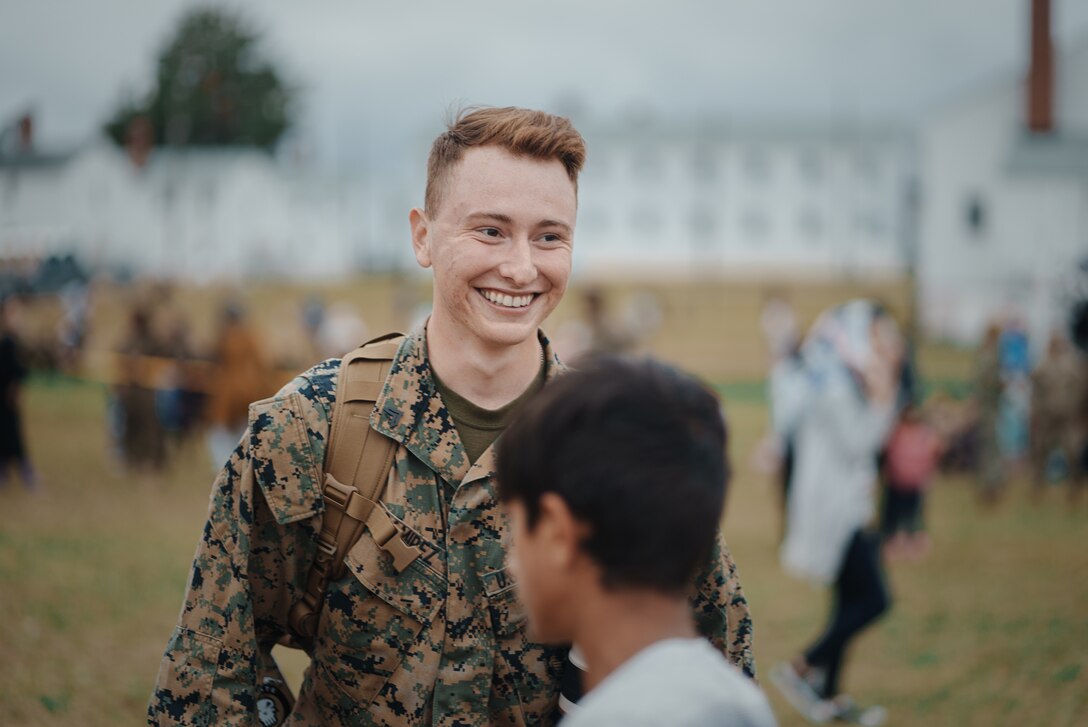 U.S. Marine Corps Cpl. Eric Ramirez, a combat videographer with the 26th Marine Expeditionary Unit, interacts with Afghan children on Fort Pickett, Virginia, Oct. 11, 2021. Ramirez was recognized as the motivator of the week for his success in producing unique and compelling visual products, highlighting events and stories occurring at Task Force Pickett. He was instrumental in creating a welcome aboard video in Dari and Pushto, communicating critical information about the immigration process to thousands of Afghan individuals at Fort Pickett. “A picture is worth a thousand words,” said Ramirez. “It is pretty amazing being able to gain a multitude of different experiences just by doing my job. Being able to capture moments during Operation Allies Welcome is an honor. It allows me to help tell the story of an operation that is history in the making. An experience like this is why I joined the Marine Corps." (U.S. Marine Corps photo by Sgt. Corey Mathews)