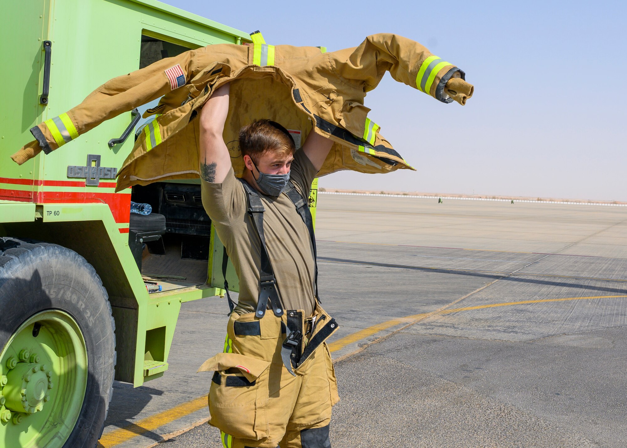 U.S. Air Force Staff Sgt. Davis Anderton, 378th Expeditionary Civil Engineer Squadron fire station chief, dawns his gear during a bilateral exercise with the Royal Saudi Air Force, Prince Sultan Air Base, Kingdom of Saudi Arabia, Sept. 6, 2021. The exercise was integral to maintaining a working relationship between RSAF and USAF first responders and ensuring seamless integration in case of future emergencies at PSAB. (U.S Air Force photo by Senior Airman Samuel Earick)