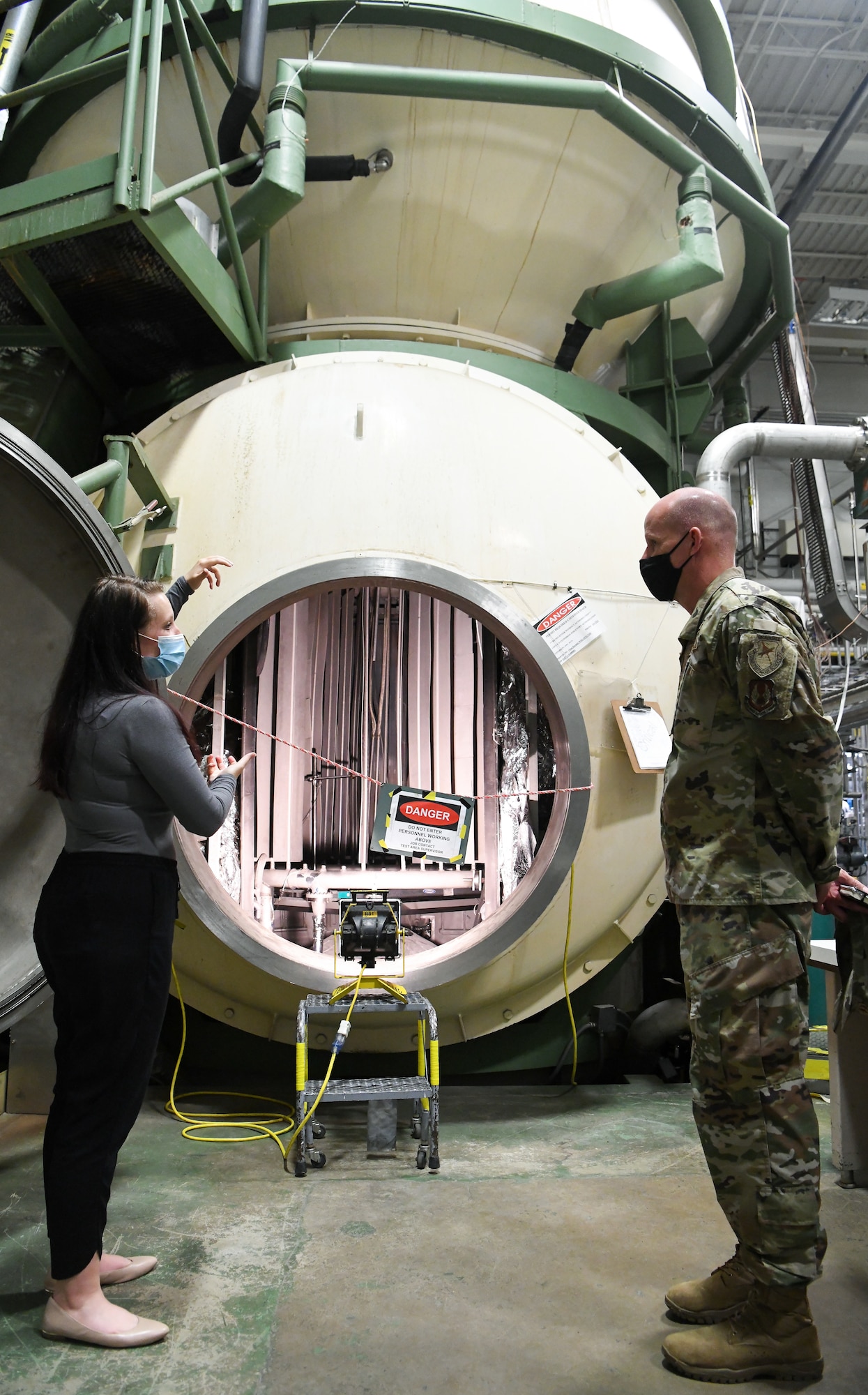 Kellye Dooley, a test engineer with the Space Test Branch of Arnold Engineering Development Complex (AEDC), speaks about the 12-foot vacuum chamber with Maj. Gen. Evan Dertien, commander, Air Force Test Center, during Dertien's visit to Arnold Air Force Base, headquarters of AEDC, Oct. 13, 2021. (U.S. Air Force photo by Jill Pickett)