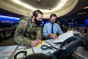 Two intelligence professionals work together in the Joint Task Force-Space Defense.