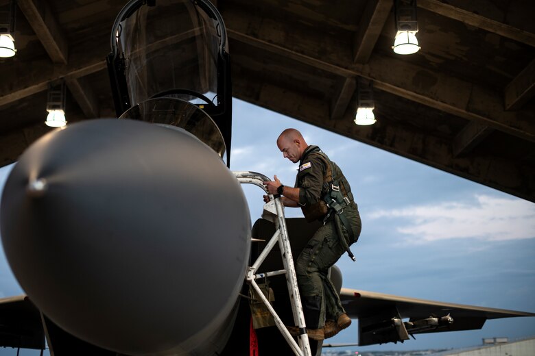 U.S. Air Force Capt. David Thomas, 67th Fighter Squadron F-15C Eagle pilot, climbs into the cockpit of an aircraft during a super surge exercise at Kadena Air Base, Japan, Oct. 19, 2021. Surge operations provide aircrew and support personnel the opportunity to hone the skills necessary to maintain a ready force, capable of ensuring peace and stability in the Indo-Pacific region. (U.S. Air Force photo by Senior Airman Jessi Monte)