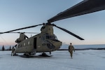 Photo of crew conducting a pre-flight inspection on a CH-47 Chinook helicopter at Fort Wainwright, Alaska.