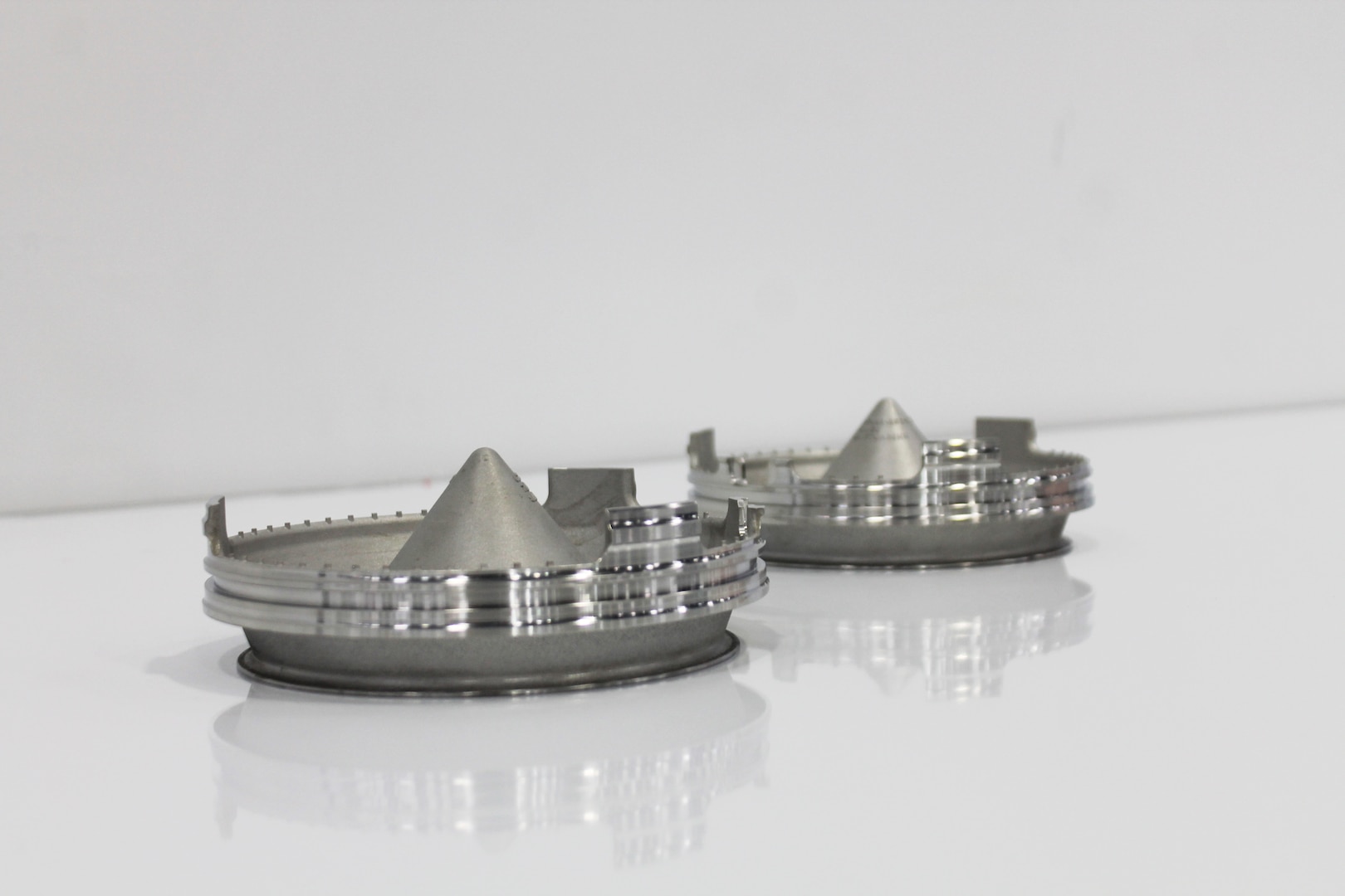 Photo of two sump pump covers created by General Electric using additive manufacturing.