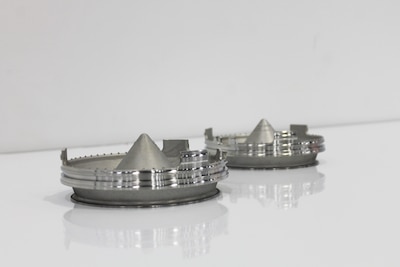 Photo of two sump pump covers created by General Electric using additive manufacturing.