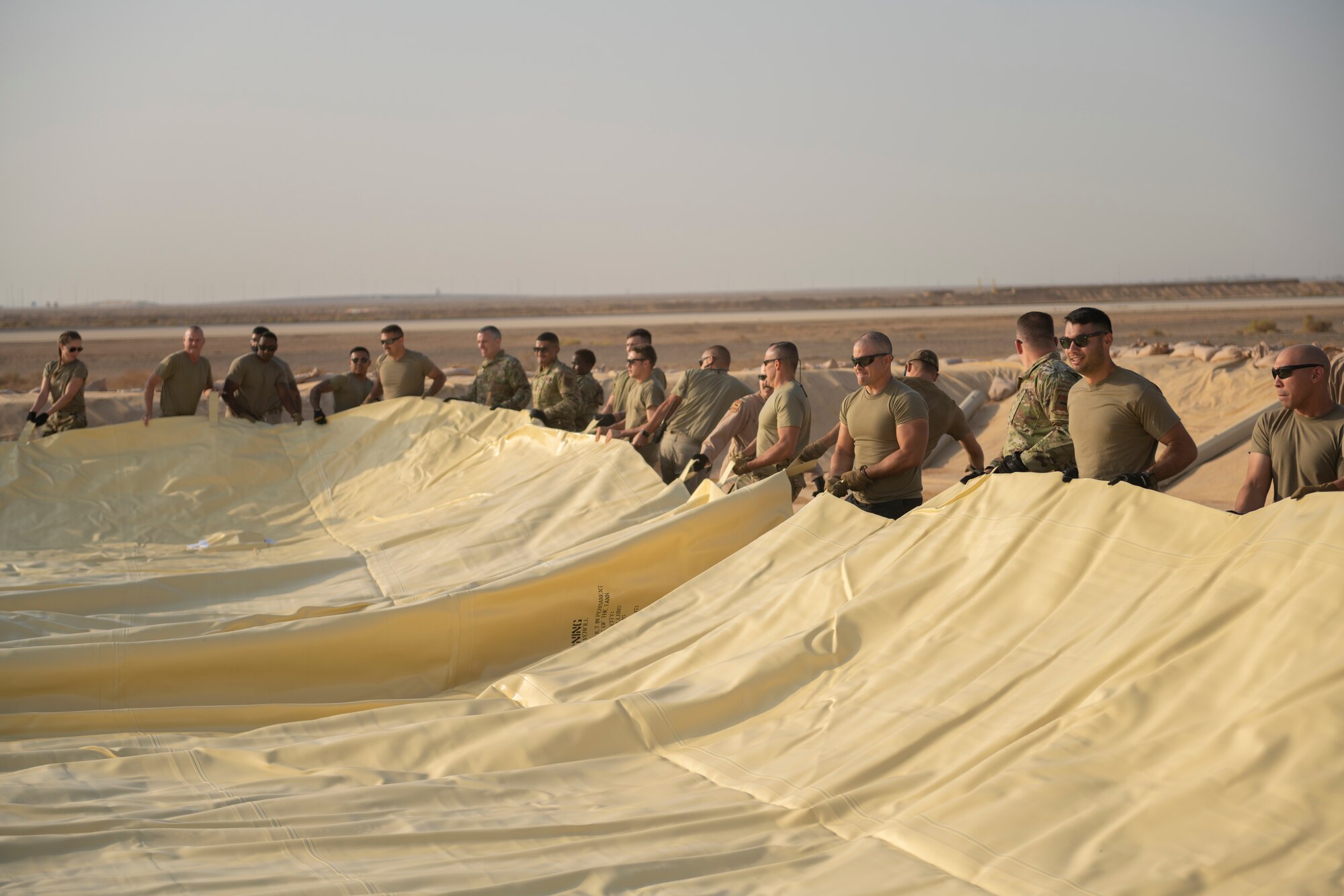 U.S. Airmen with the 332nd Air Expeditionary Wing spread out a collapsible fabric tank