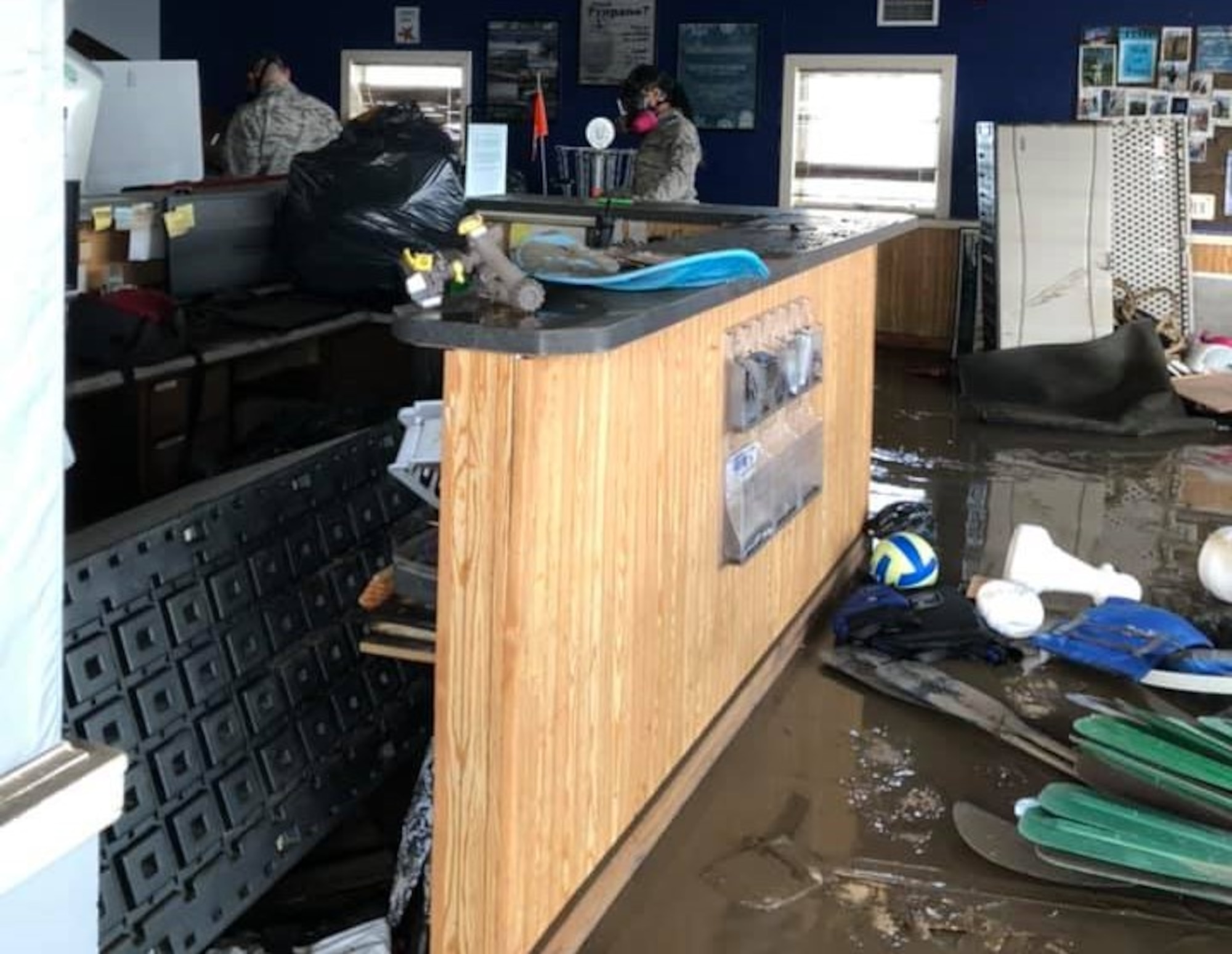 Airmen survey damage after flooding at a recreation center at Offutt Air Force Base, Neb. in  2019. A season of heavy snowfall, combined with a late winter storm in the middle of March 2019, left roughly 30% of the installation flooded.