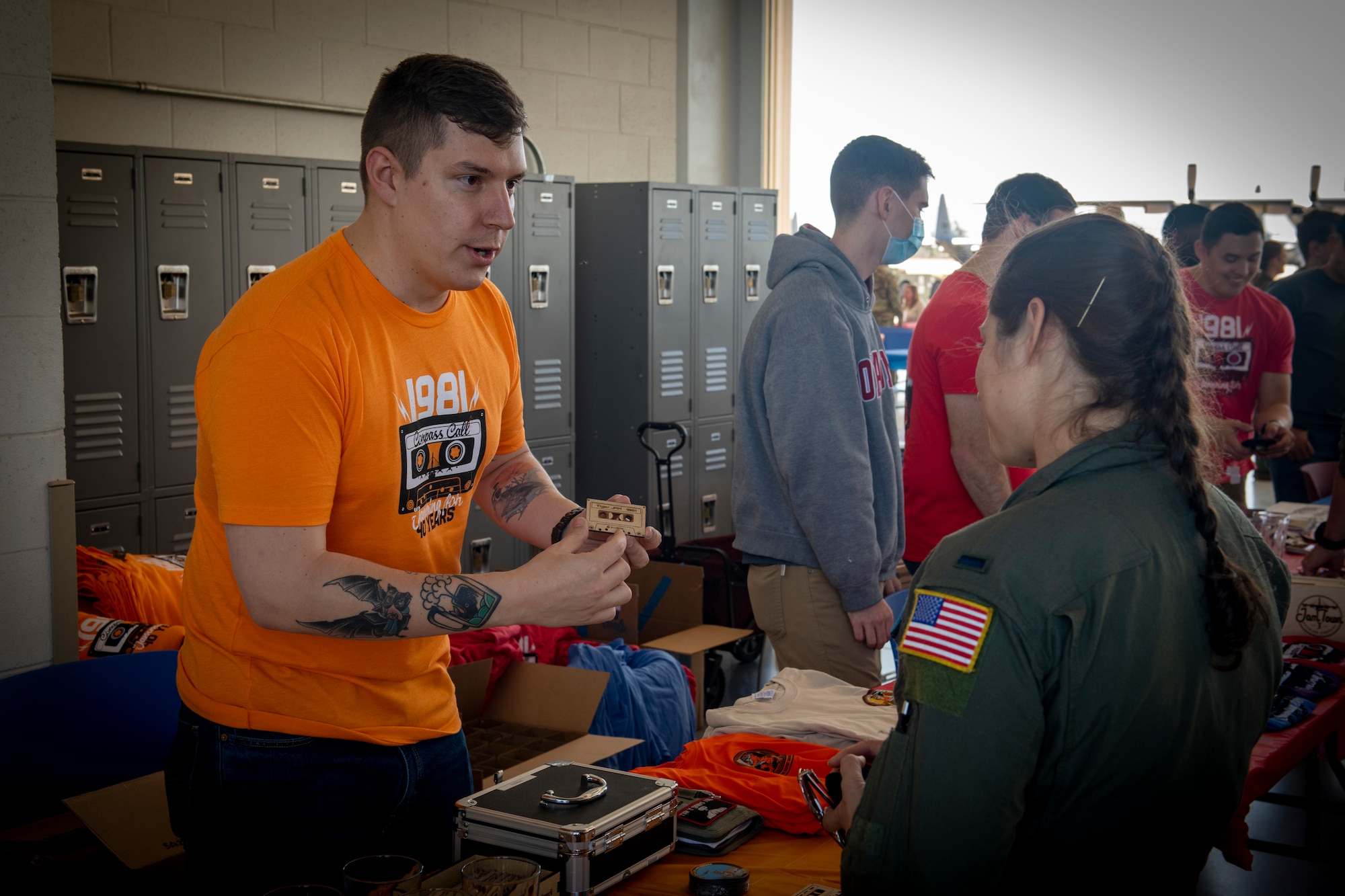 An active duty member shows a squadron magnet to another active duty member