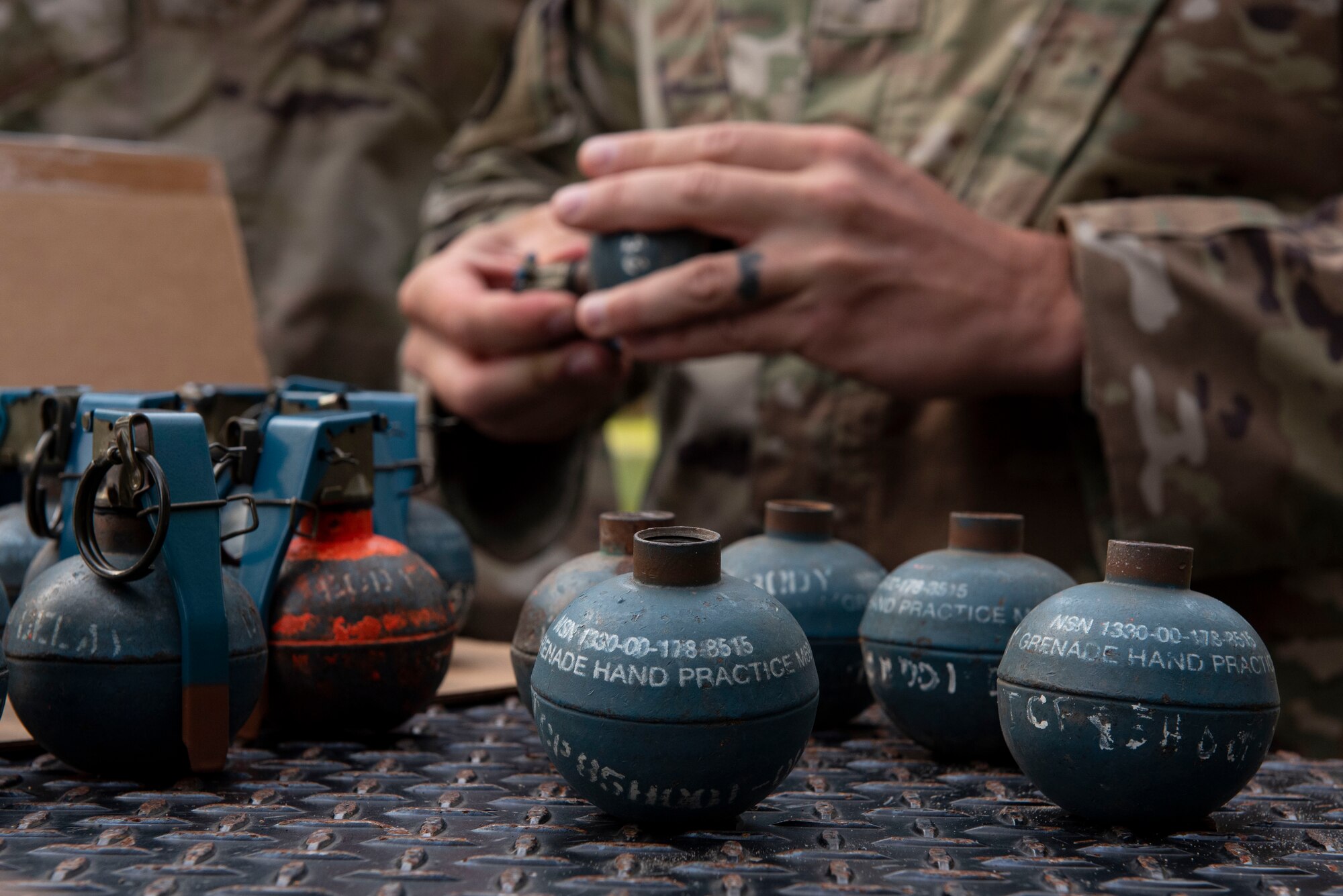 A photo of an Airman clearing a grenade of shrapnel.