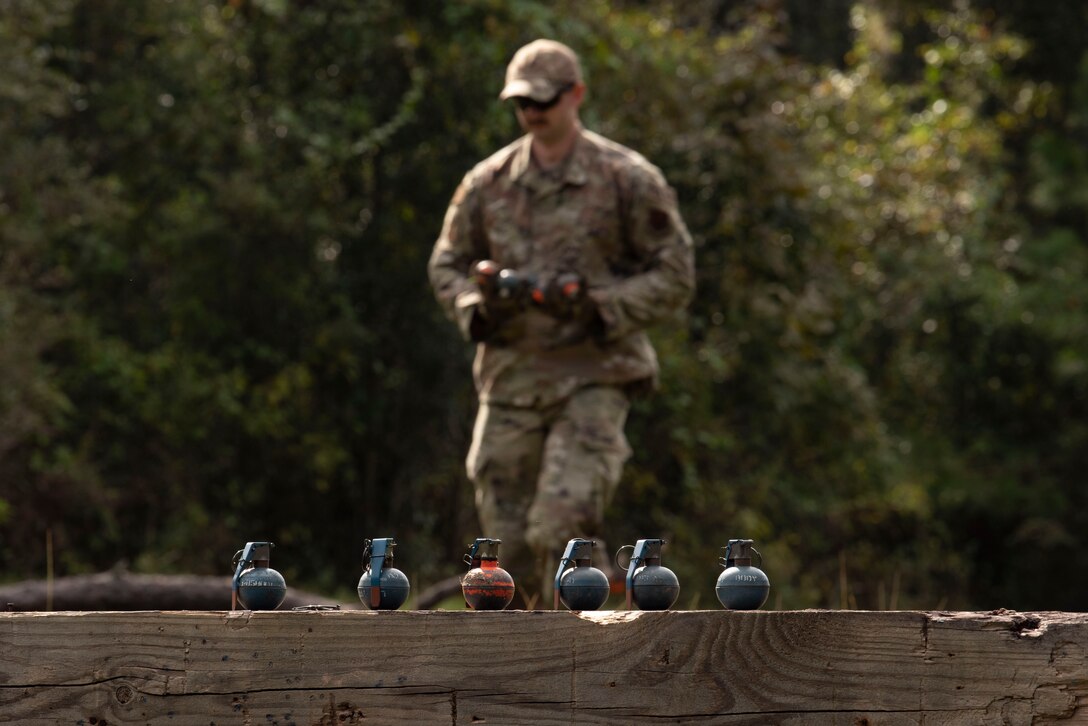 A photo of an Airman collecting used grenades.