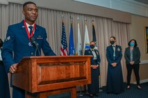 Senior Airman Jachin Henderson, Joint Personal Property Shipping Office Northeast shipment distribution technician, speaks during the Airman Leadership School graduation at Hanscom Air Force Base, Mass., Oct. 21, while Col. Katrina Stephens, installation commander, Chief Master Sgt. Holly Burke, acting installation command chief, and retired Lt. Col. Debra Zides, AFCEA vice president of education, look on. Henderson received the John Levitow award for demonstrating the highest degree of excellence as a leader and a scholar throughout the course. (U.S. Air Force photo by Todd Maki)