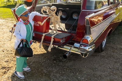 Boy dressed up as a doctor participates in trunk-or-treating.